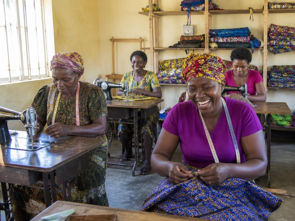 Women learning tailoring skills on sewing machines in a vocational training workshop