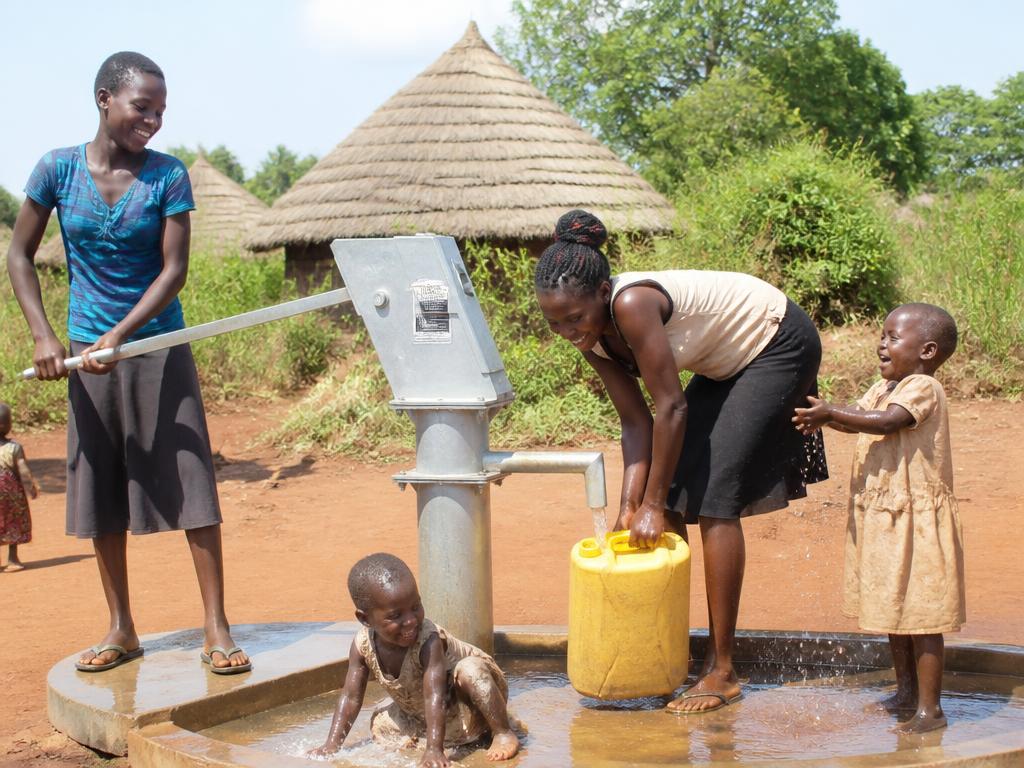 Children filling jerrycans with clean water at a village handpump